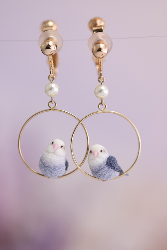 Complete pair of violet lovebird hoop earrings with clip-on fittings and clear pads, white beads and both bird poses.