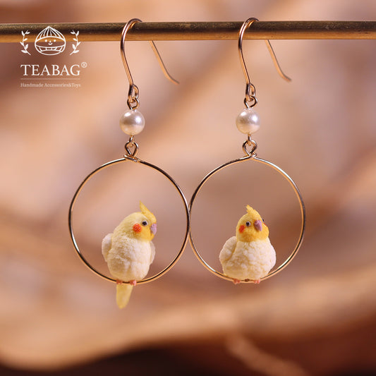 Pair of cockatiel hoop earrings with both pierced hooks and white beads fully visible.