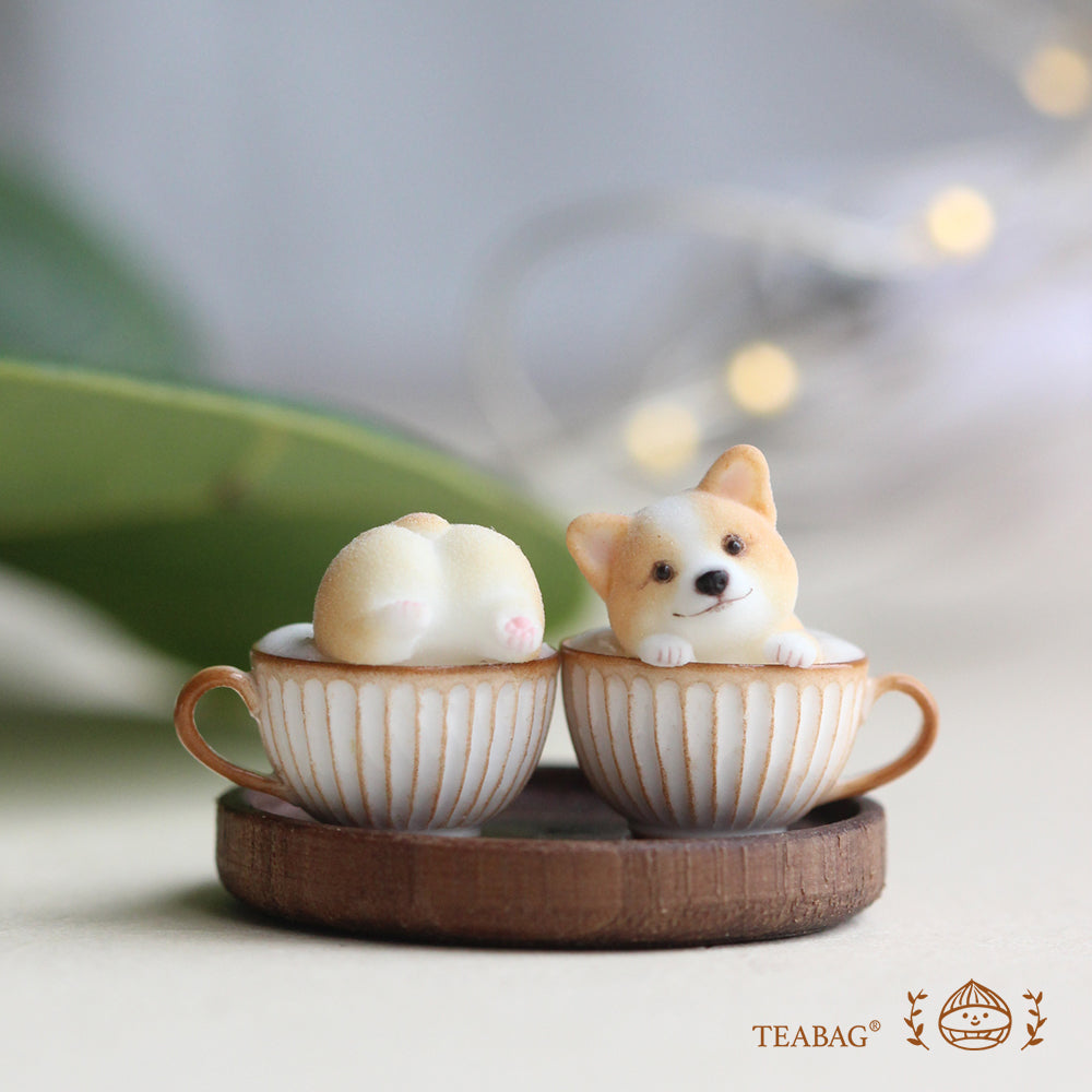Matching Corgi Coffee miniatures: one front-facing head and one upturned bottom in cream-and-gold cups on a wooden tray. Design reference only; miniatures and tray are not included with the necklace.
