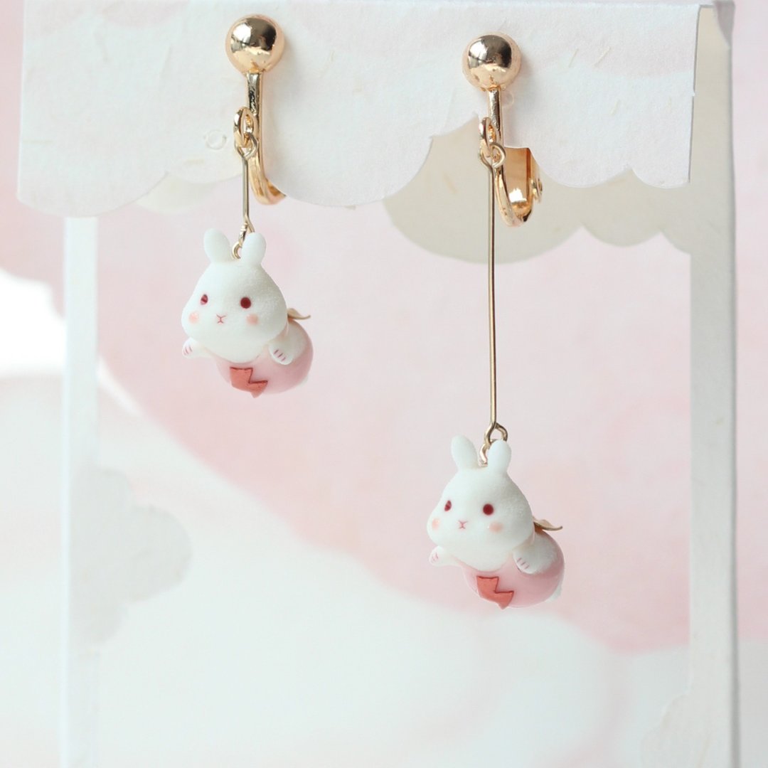 Asymmetric pair of flying-bunny clip-on earrings, with one short and one long fitting.