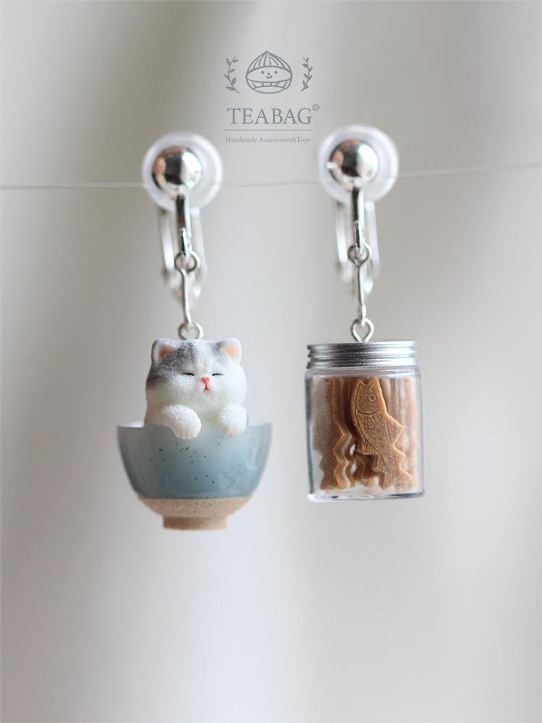 Clip-on Kitten Bakery earrings, showing the kitten-in-a-bowl and cookie-jar charms.