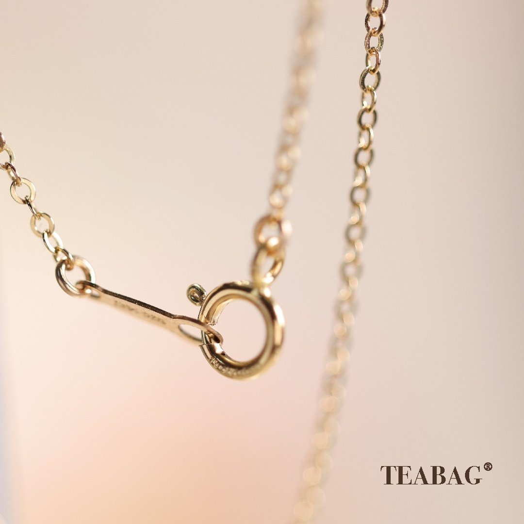 Close-up of the necklace chain's round clasp and connecting links.
