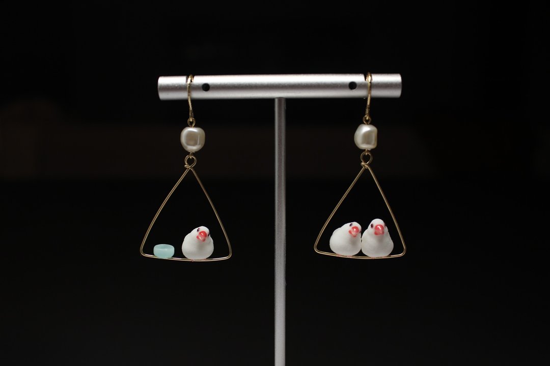 Java sparrow earrings on a stand, comparing a single-bird arrangement with a two-bird arrangement.