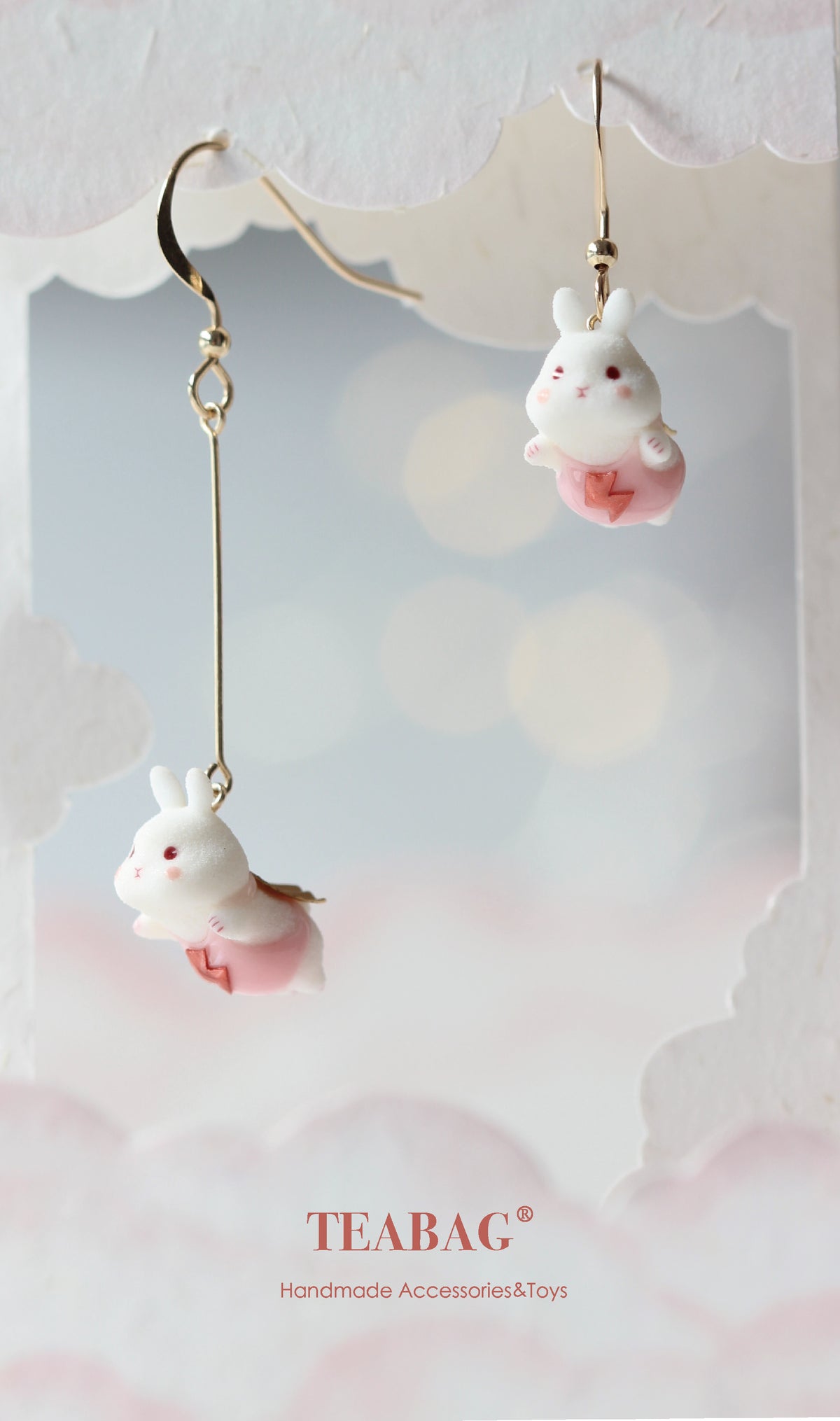 Pair of Flying Bunny pierced-hook earrings, one short and one long with a straight extension, shown together on a display card with TEABAG branding.